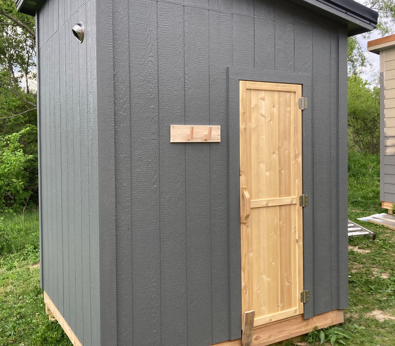Close-up of the sauna's cedar door and dark siding